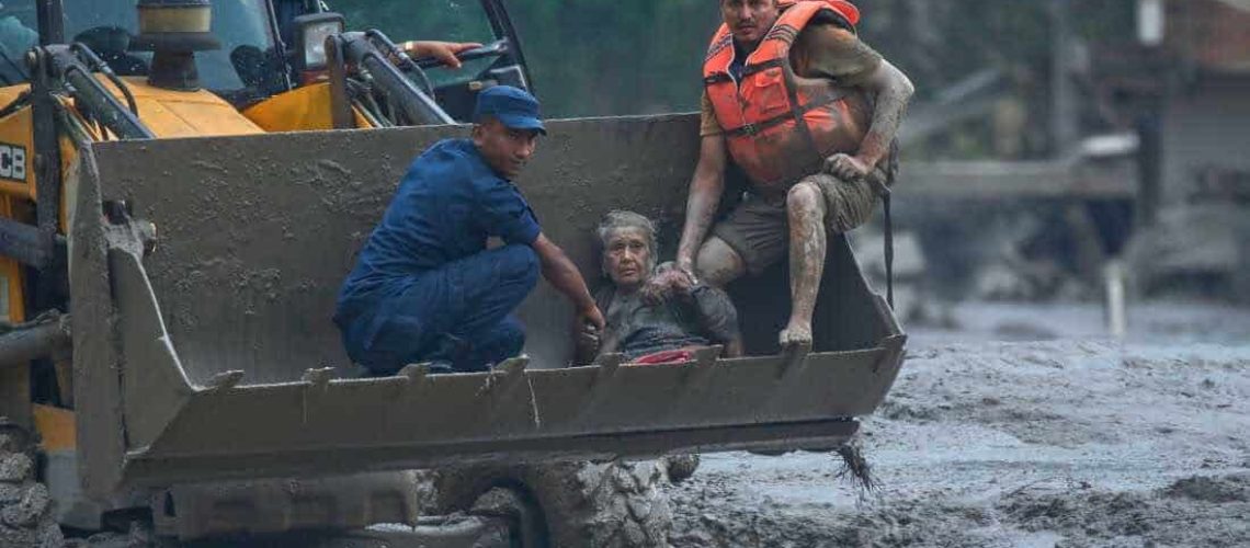 Rescuers use an earthmover to carry a victim of flash flooding to safety along the Trishuli River in Nepal's Nuwakot district, Wednesday, Aug. 26, 2026. (AP Photo/Niranjan Shrestha)